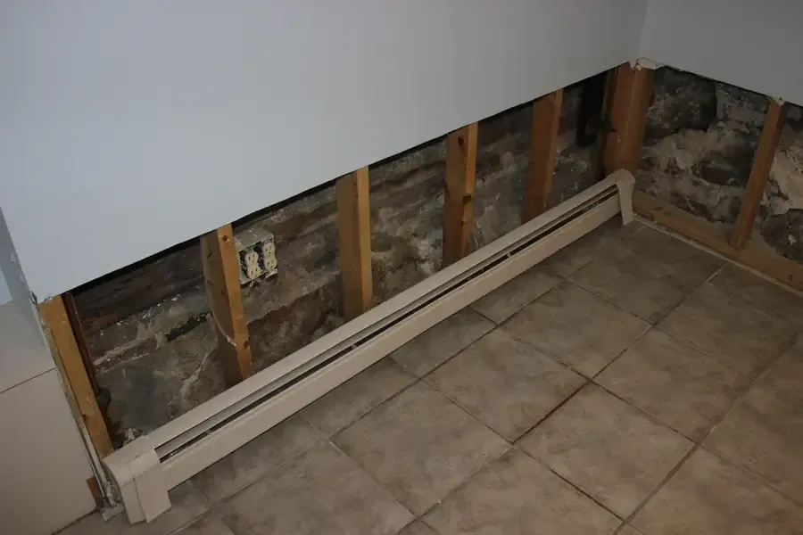 Drywall cut away along the bottom of a wall so the cavity can dry