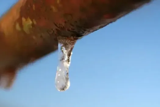 An icicle hanging from a rusted pipe during a hard freeze